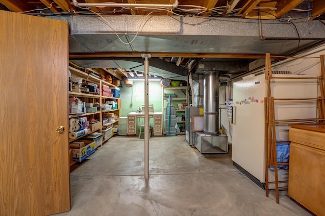 unfinished basement with freestanding refrigerator