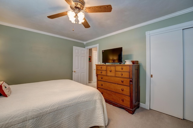 bedroom with ornamental molding, a ceiling fan, a closet, and light carpet