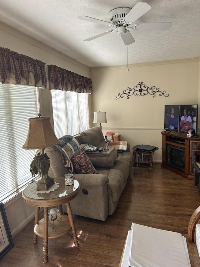 living room with ceiling fan, dark hardwood / wood-style floors, a fireplace, and a textured ceiling