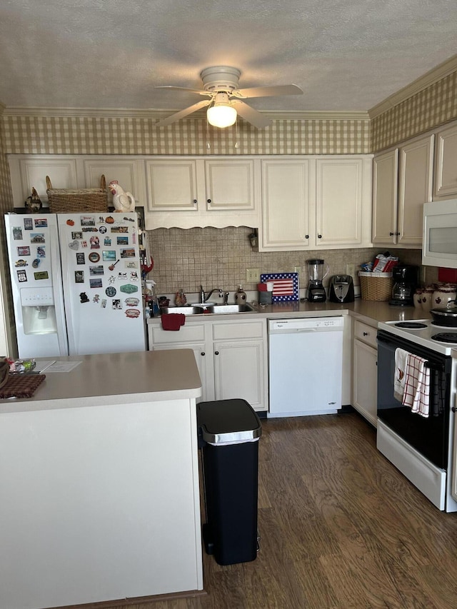 kitchen with sink, white appliances, dark hardwood / wood-style floors, a textured ceiling, and white cabinets