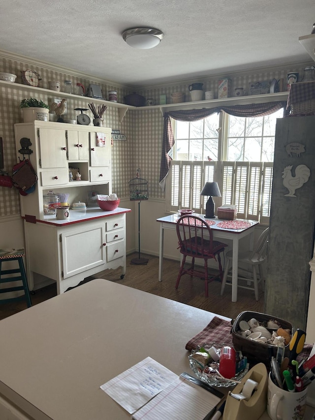 kitchen with dark wood-type flooring, white cabinets, and a textured ceiling