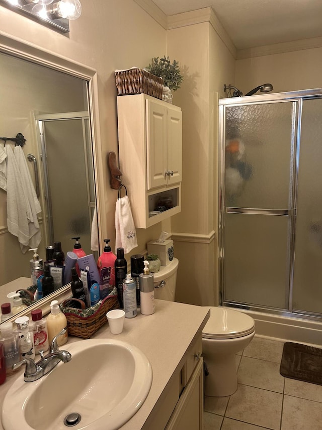 bathroom with tile patterned flooring, ornamental molding, and a shower with door