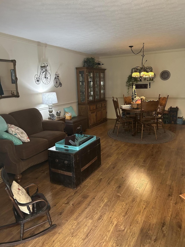 living room with hardwood / wood-style flooring, ornamental molding, and a textured ceiling