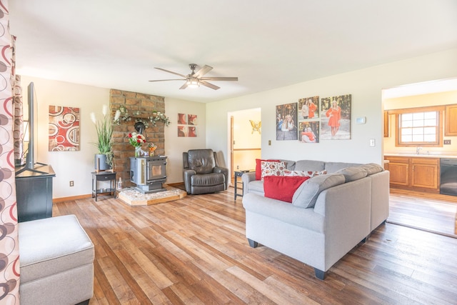 9162 Township Road 169 N, West Liberty, OH 43357 - living area with a wood stove, light wood-style flooring, ceiling fan, and baseboards