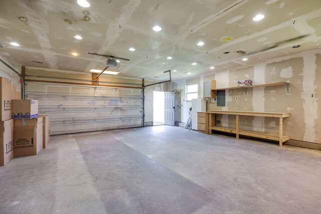 garage featuring a garage door opener, electric panel, and recessed lighting