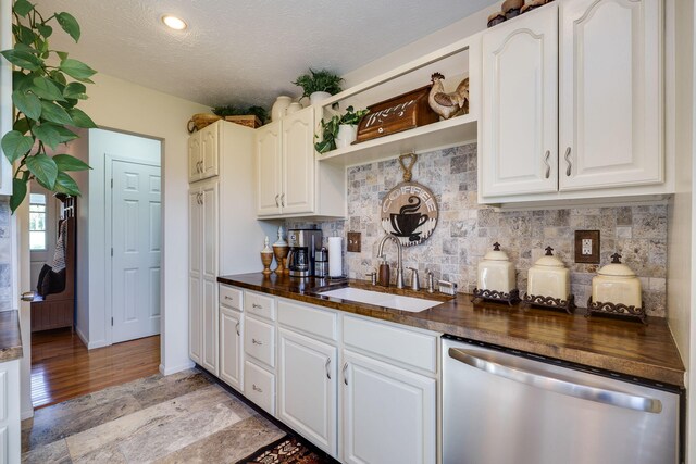 kitchen featuring decorative backsplash, stainless steel dishwasher, open shelves, a sink, and white cabinets