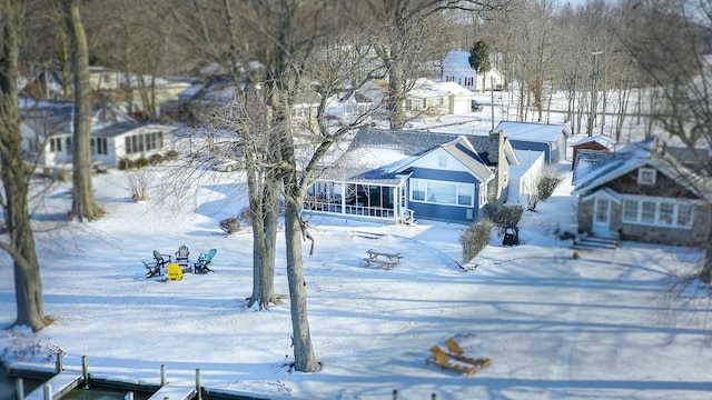 yard covered in snow with entry steps and a sunroom