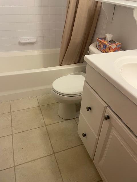 bathroom featuring toilet, tile patterned flooring, vanity, and shower / bathtub combination with curtain