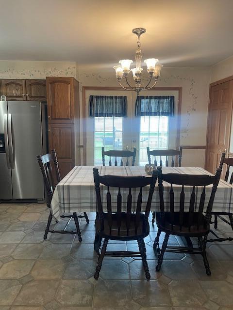dining space featuring a notable chandelier and stone finish flooring
