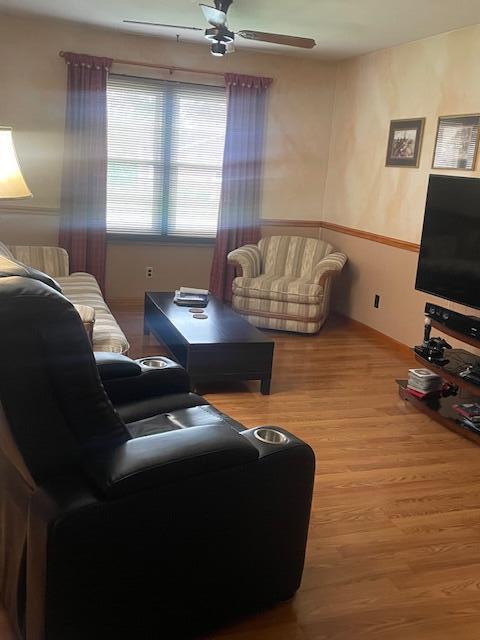 living room with ceiling fan and wood finished floors