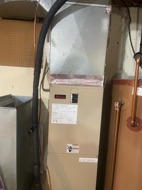 utility room with gas water heater and heating unit