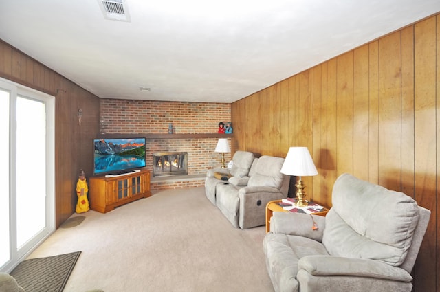 carpeted living room with a brick fireplace, plenty of natural light, and wooden walls