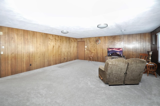 living area featuring carpet flooring and wood walls