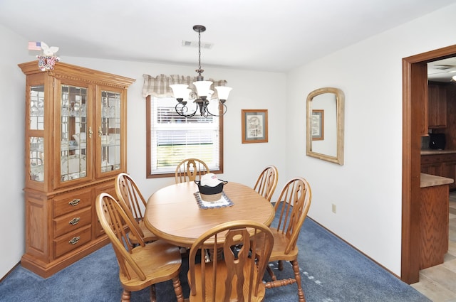 dining area with light carpet and a notable chandelier