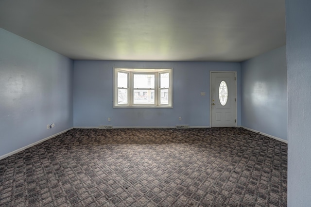 carpeted foyer entrance featuring baseboards