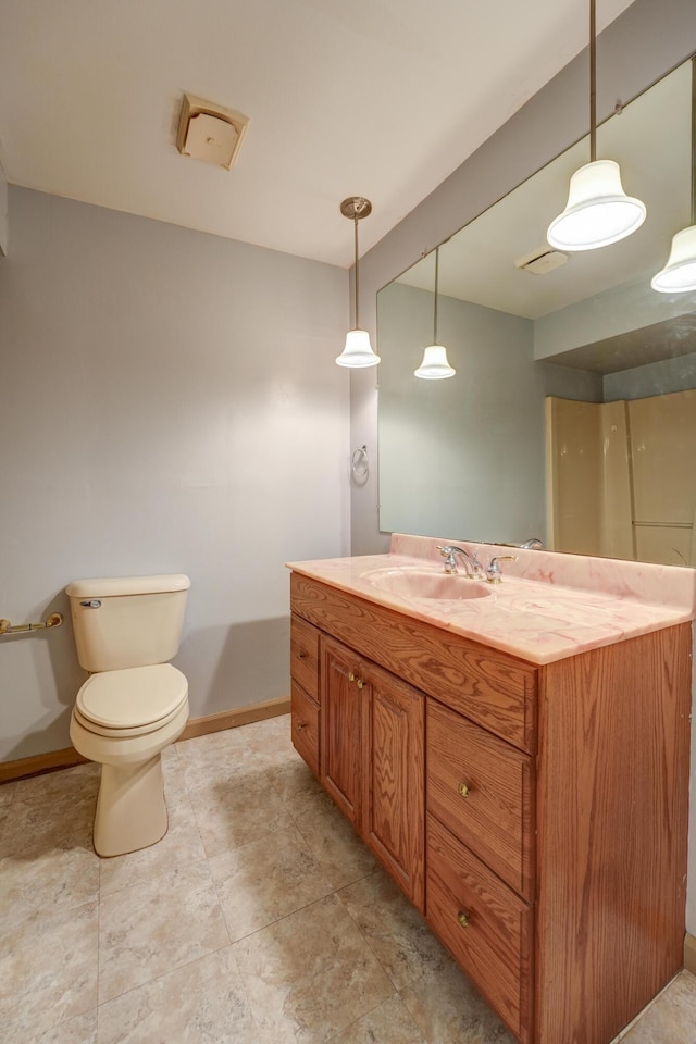 bathroom with baseboards, toilet, and vanity