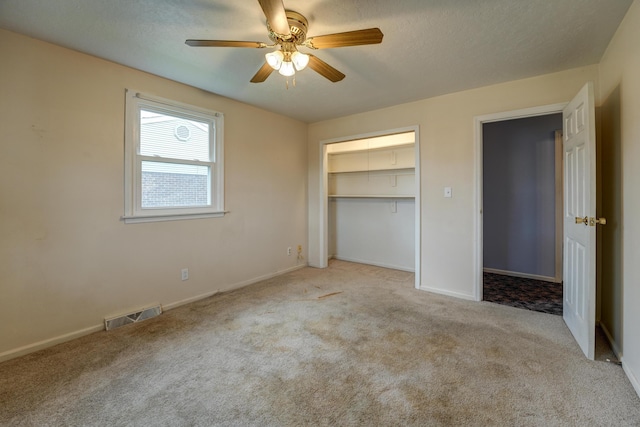 unfurnished bedroom with carpet flooring, a textured ceiling, a closet, and visible vents