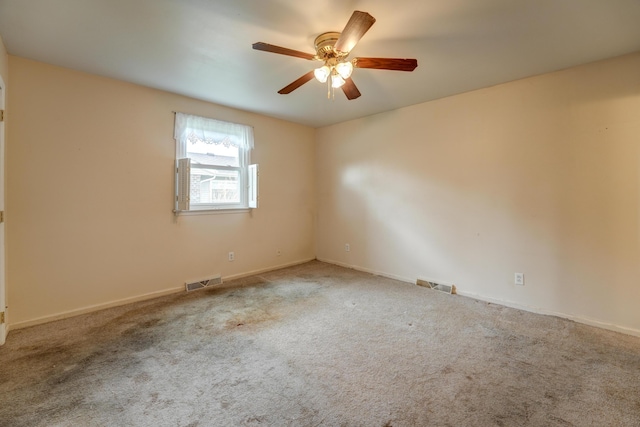 carpeted empty room with ceiling fan and visible vents