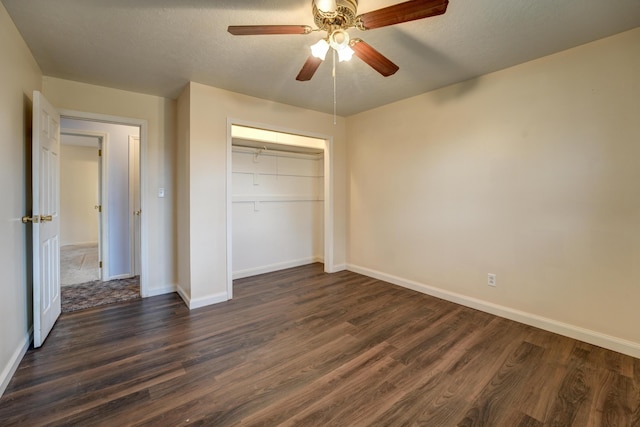 unfurnished bedroom with dark wood-type flooring, baseboards, and a closet