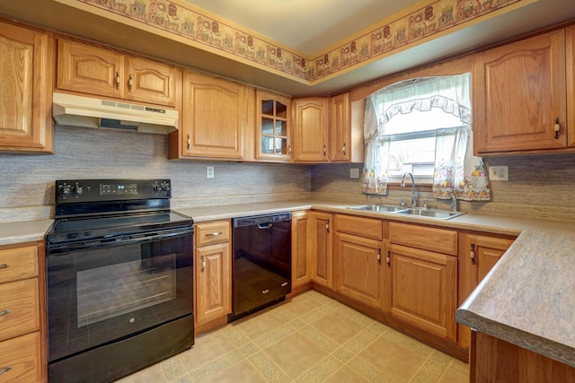 kitchen with light countertops, under cabinet range hood, a sink, black appliances, and backsplash