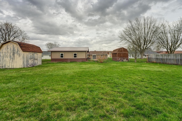 view of yard with an outbuilding, fence, and a barn