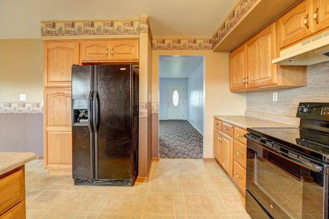 kitchen with light countertops, under cabinet range hood, tasteful backsplash, and black appliances