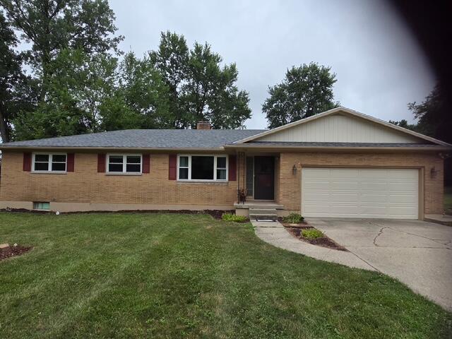 1401 E Home Rd, Springfield, OH 45503 - ranch-style house with concrete driveway, a garage, and a front lawn