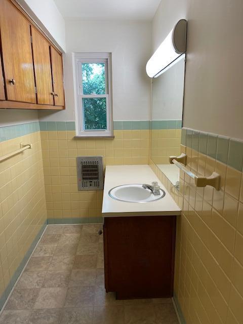 1401 E Home Rd, Springfield, OH 45503 - bathroom featuring tile walls, vanity, wainscoting, heating unit, and tile patterned floors
