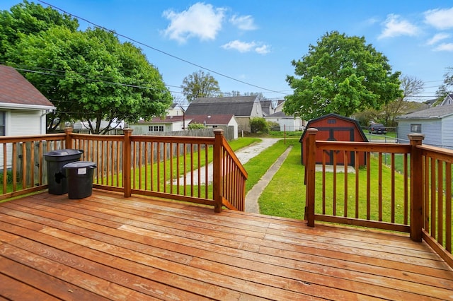 wooden terrace featuring a storage shed, a lawn, a residential view, an outdoor structure, and a fenced backyard