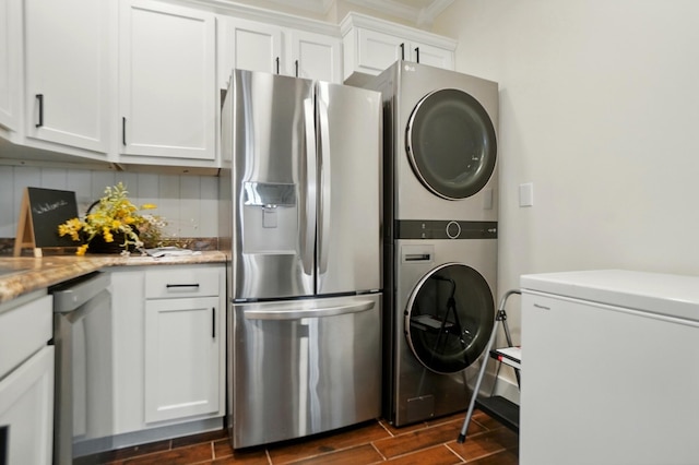 washroom with wood finish floors, ornamental molding, and stacked washer and clothes dryer
