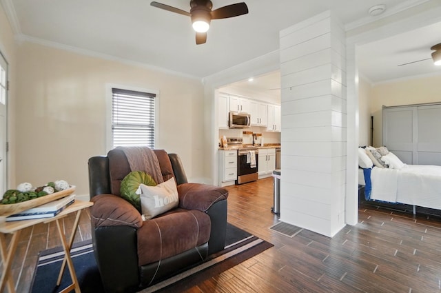 living area featuring dark wood-type flooring, ornamental molding, and ceiling fan
