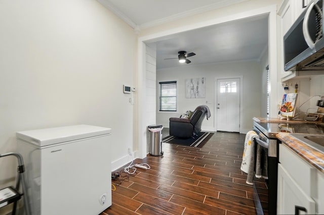 interior space with white refrigerator, electric range oven, stainless steel microwave, and ornamental molding