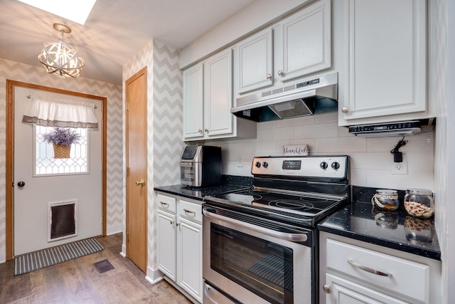 4212 Midfield St, Springfield, OH 45503 - kitchen featuring stainless steel range with electric cooktop, under cabinet range hood, a chandelier, tasteful backsplash, and white cabinetry