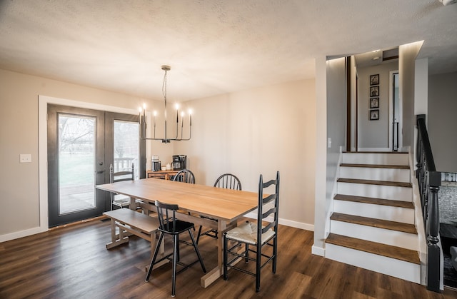 dining area with an inviting chandelier, dark wood-type flooring, and a textured ceiling