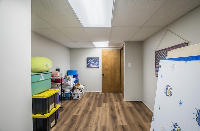 interior space with hardwood / wood-style floors and a drop ceiling