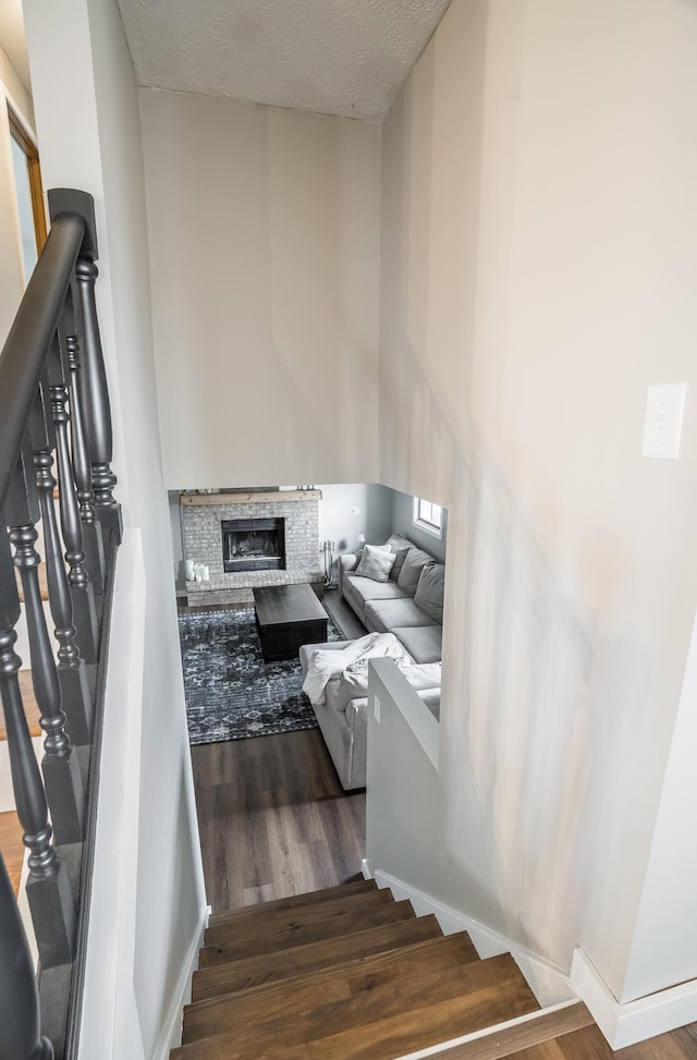 stairway featuring wood-type flooring and a textured ceiling