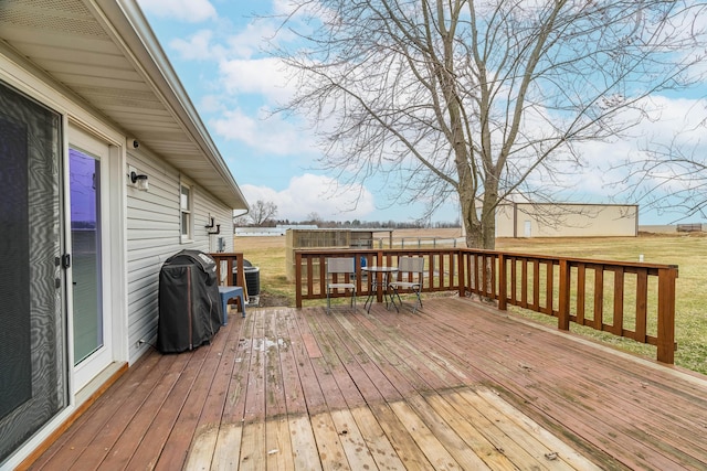 wooden terrace featuring grilling area and a yard