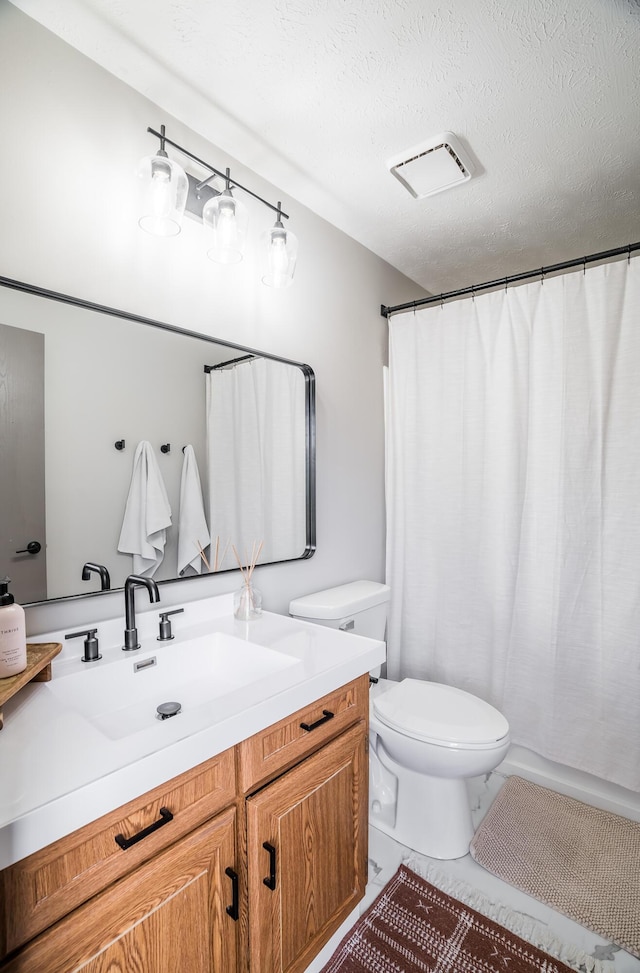 bathroom featuring vanity, toilet, and a textured ceiling