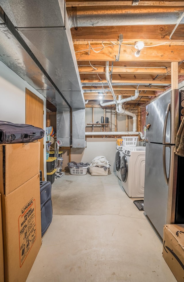 basement featuring stainless steel refrigerator and washer and dryer