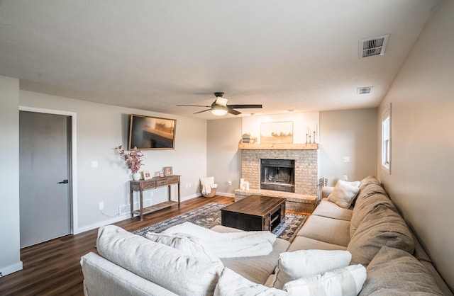 living room featuring ceiling fan, a fireplace, and dark hardwood / wood-style flooring