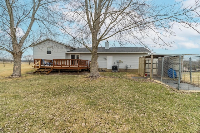 rear view of property with central AC, a deck, and a lawn