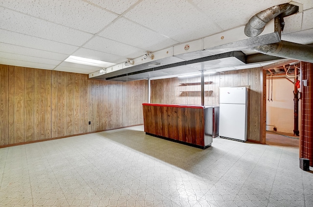 2831 Wellsford Ln, Springfield, OH 45503 - finished basement with freestanding refrigerator, light floors, wooden walls, a bar, and a paneled ceiling