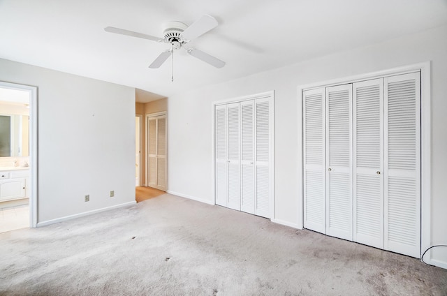 2831 Wellsford Ln, Springfield, OH 45503 - unfurnished bedroom featuring multiple closets, carpet floors, baseboards, ensuite bath, and a ceiling fan