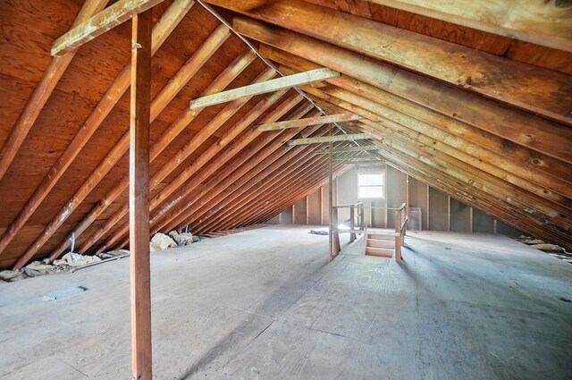 unfinished attic with an upstairs landing