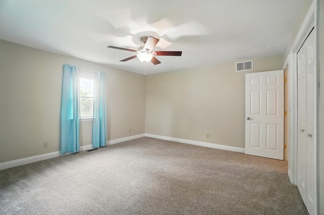 unfurnished bedroom featuring carpet, a closet, baseboards, and a ceiling fan