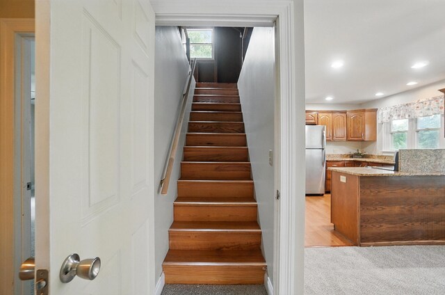 stairway with plenty of natural light, carpet, and recessed lighting