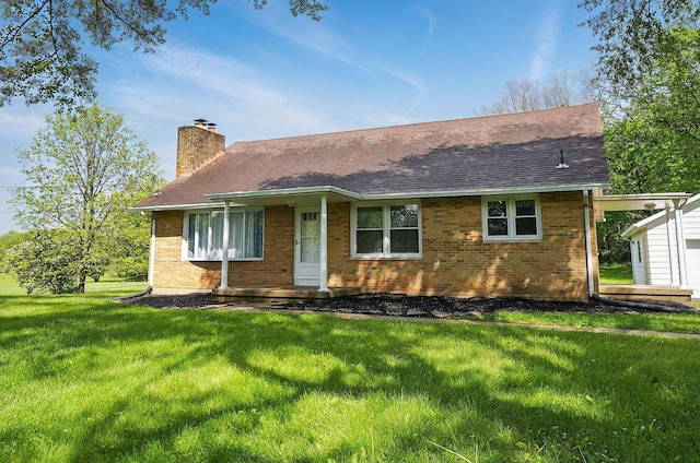 view of front of house with a chimney, a front lawn, brick siding, and roof with shingles