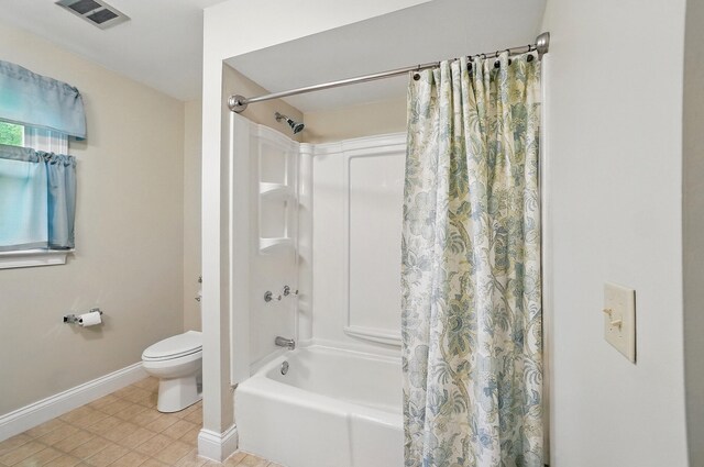 bathroom with baseboards, shower / bath combo with shower curtain, and toilet