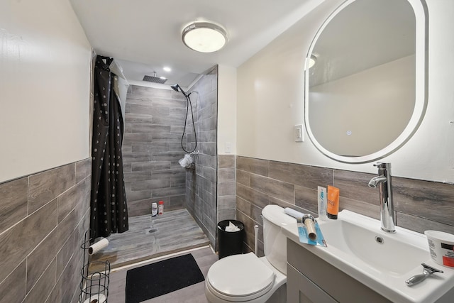 1566 Cora St, Springfield, OH 45503 - bathroom featuring tile walls, a tile shower, vanity, toilet, and wainscoting