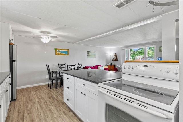 kitchen with light hardwood / wood-style floors, electric stove, ceiling fan, dark stone counters, and white cabinets